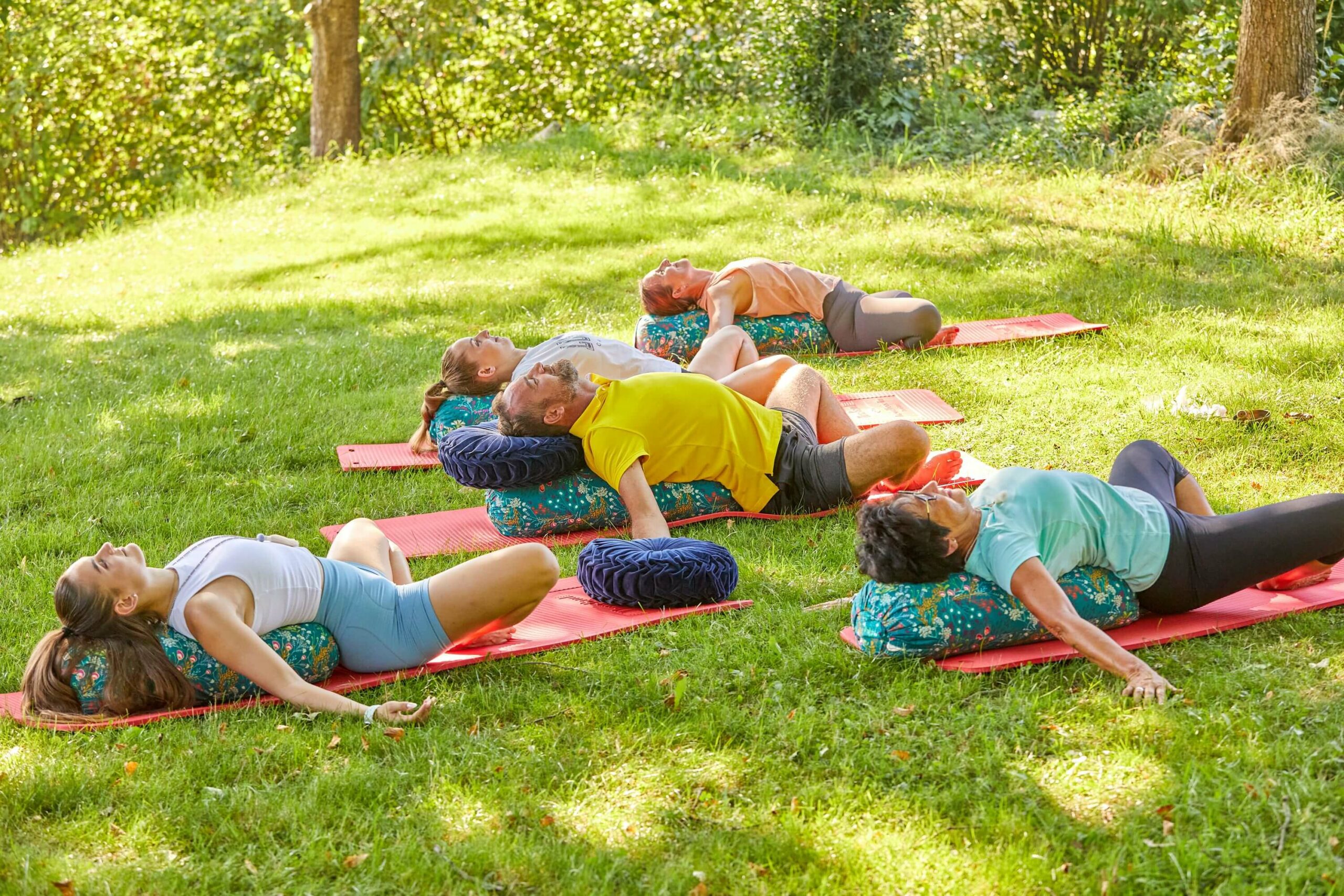 mehrere Personen bei einer Yoga Übung im Freien
