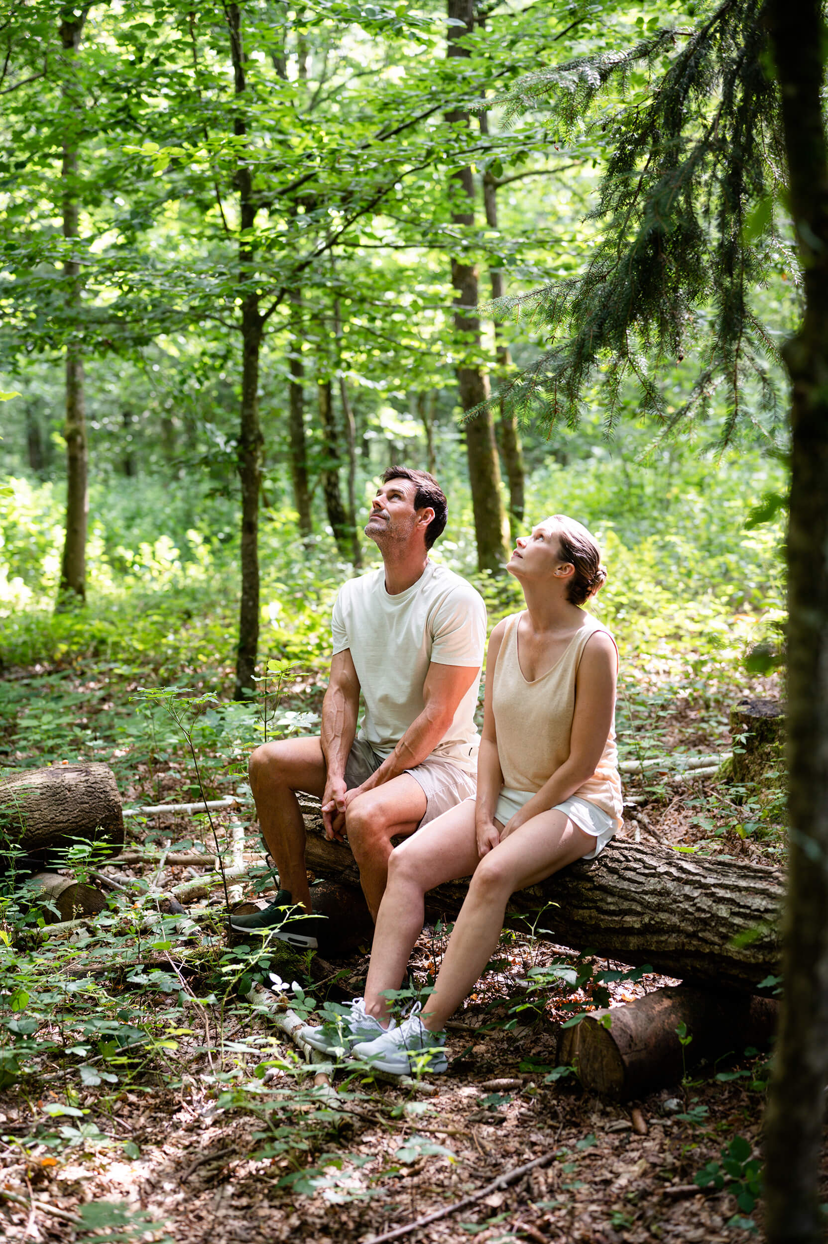 Zwei Personen auf einem Baumstamm sitzend in den Himmel blickend